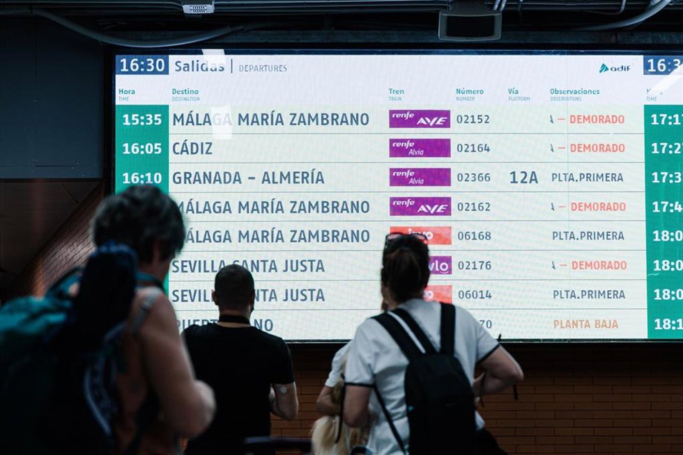 Archivo - Varias personas observan una pantalla informativa en la Estación de Madrid - Puerta de Atocha - Almudena Grandes, a 30 de agosto de 2025, en Madrid (España). El tráfico ferroviario entre Madrid y Andalucía se encuentra cortado por un incendio