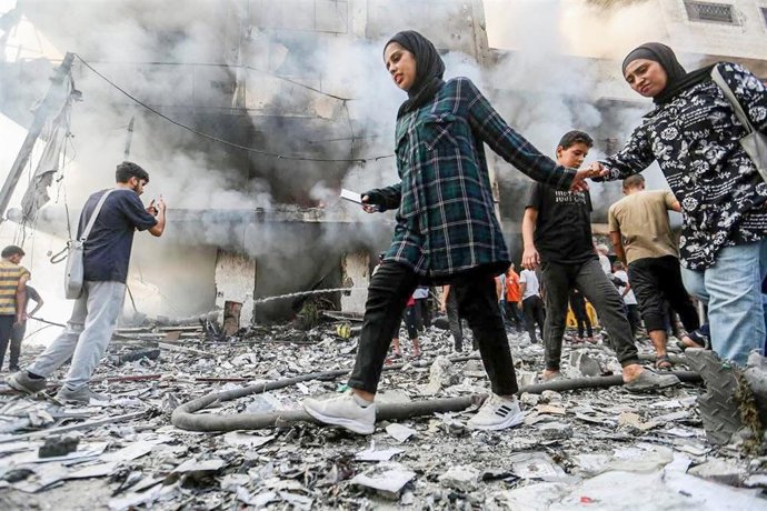 28 September 2025, Palestinian Territories, Gaza: Palestinians move outside a building damaged in an Israeli air strike. Photo: Hasan Alzaanin/TASS via ZUMA Press/dpa