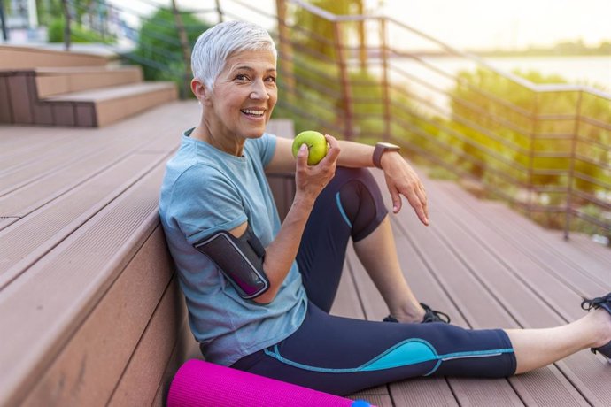 Archivo - Mujer deportista comiendo una manzana.