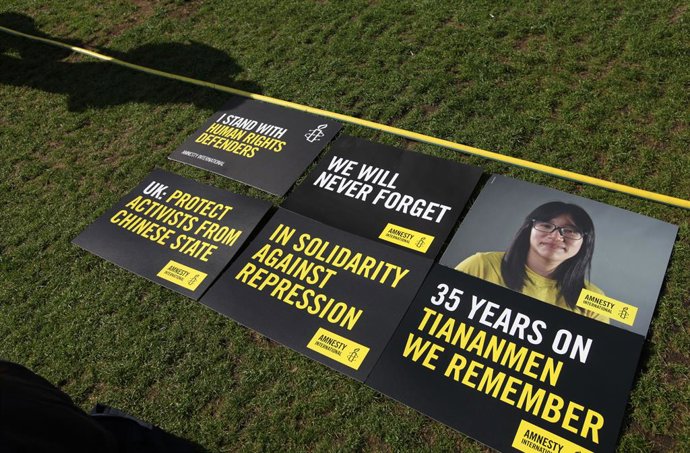 Archivo - June 2, 2024, London, England, UK: Protester's signs lay on the grass with a protester's shadow nearby, one showing a picture of Chow Hang-Tung during the demonstration in Parliament Square. The event commemorated the1989 student-led protests an