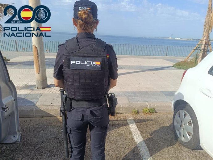 Una agente de la Policía Nacional, de espaldas.