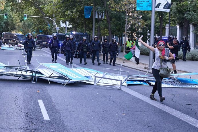 Vallas tiradas tras las cargas policiales a varias personas que protestan a favor de Palestina en la calle Atocha durante el paso de La Vuelta 2025