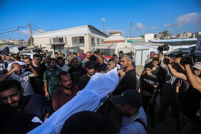 Palestinos trasladan el cuerpo de un muerto por un ataque del Ejército de Israel en Deir al Balá, en el centro de la Franja de Gaza