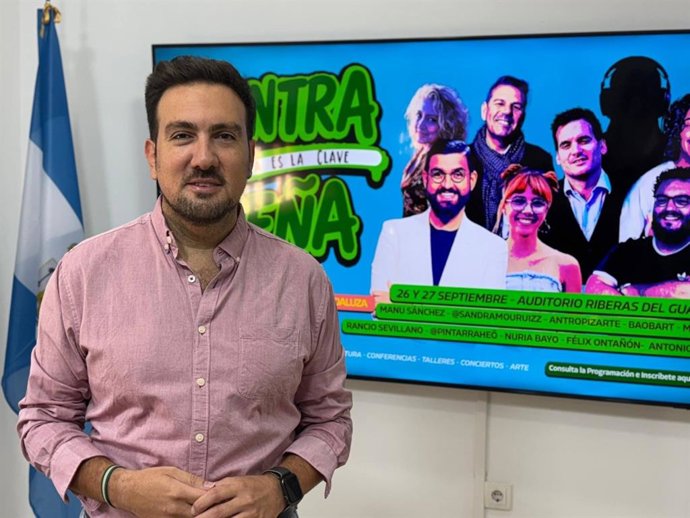 Delegado de Identidad Andaluza del Ayuntamiento de Alcalá de Guadaíra (Sevilla), Christopher Rivas, junto al cartel de ContraSeña.