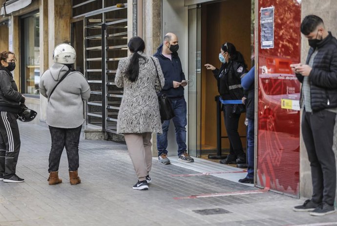 Archivo - Diverses persones amb cita prèvia esperen per a entrar en una oficina del SEPE (antic INEM), a València