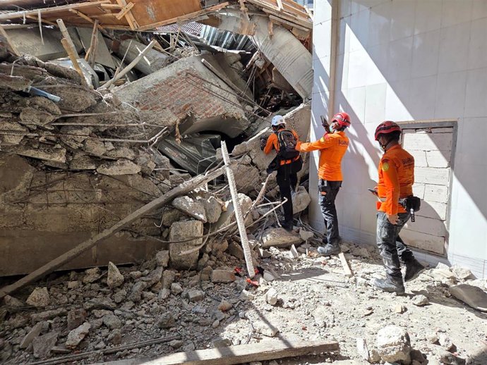 Miembros del servicio de búsqueda y rescate de Indonesia tratando de sacar con vida a las víctimas del derrumbe en una escuela islámica de Indonesia.