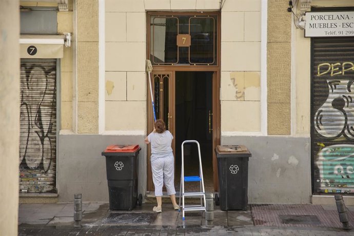 Archivo - Una trabajadora limpia un portal, a 28 de julio de 2022, en Madrid (España) . Foto de archivo.