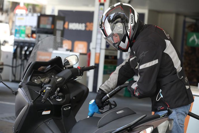 Archivo - Un hombre echa gasolina a su moto