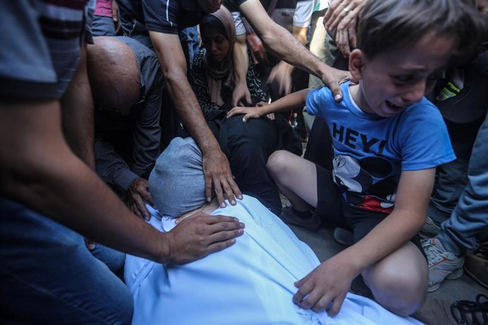 Familiares de un palestino muerto por un ataque del Ejército de Israel contra la Franja de Gaza junto a su cadáver en el Hospital Mártires de Al Aqsa, en Deir al Balá (archivo)