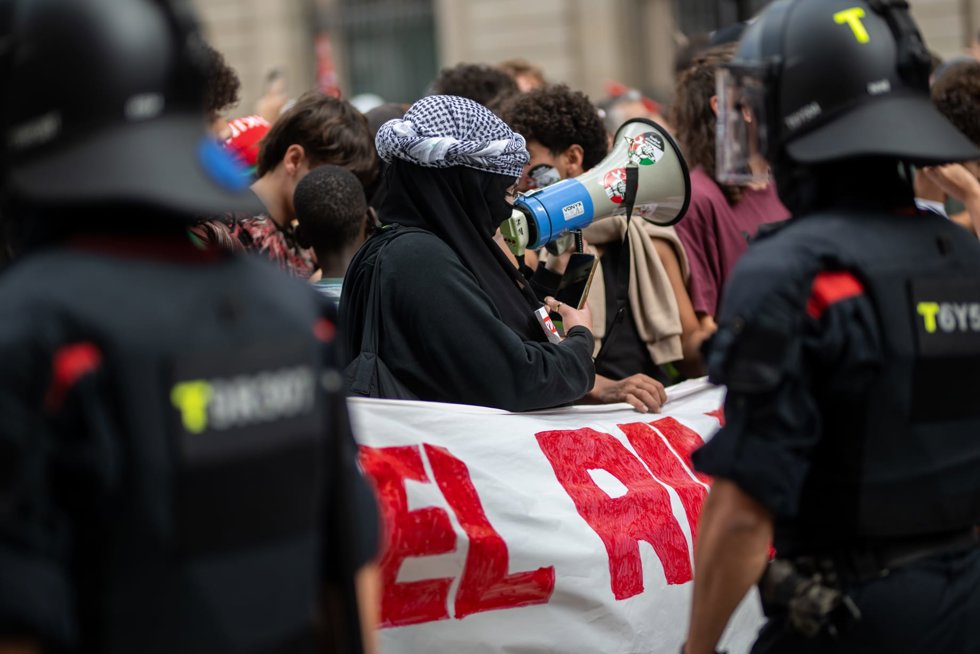Manifestantes ante agentes del Área Regional de Recursos Operativos (ARRO) de los Mossos d'Esquadra en la plaza de Sant Jaume