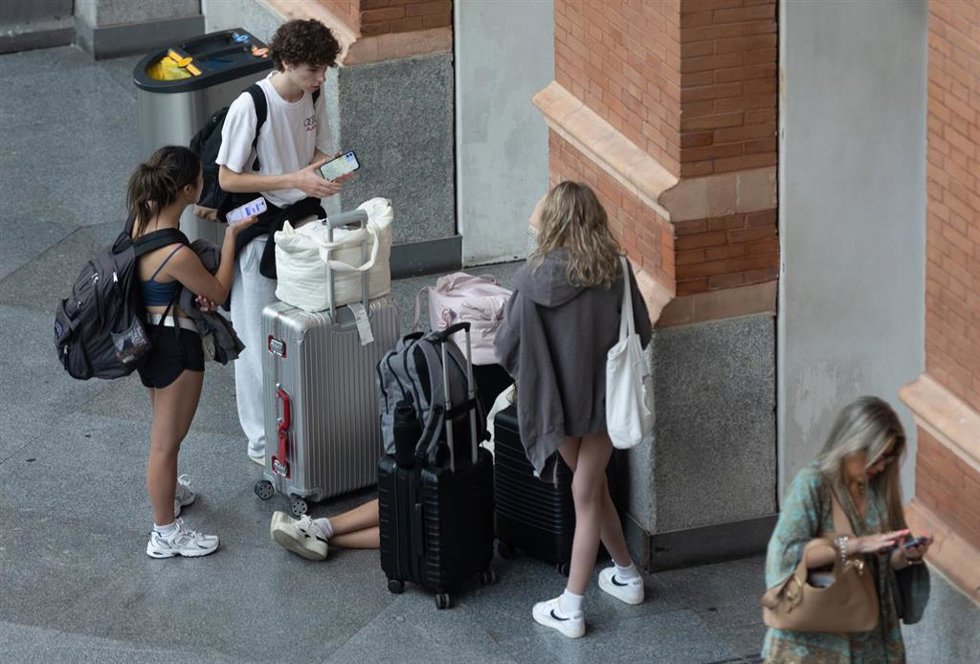 Archivo - Varias personas con maletas en la estación de Puerta de Atocha-Almudena Grandes.