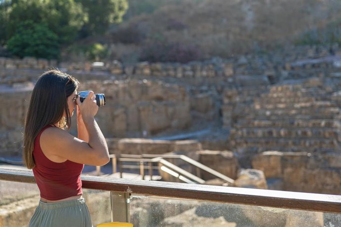 Archivo - Una turista toma una foto en el Teatro Romano de Málaga.