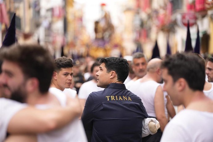 El periodista José Antonio Rodríguez, de espaldas y con una camisa azul, como costalero de la hermandad de la Esperanza de Triana.