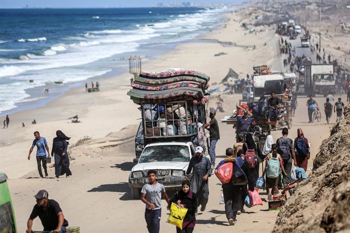 1 de outubro de 2025, Nuseirat, Faixa de Gaza, Território Palestino: Palestinos carregando pertences chegam a um caminho costeiro a noroeste do campo de refugiados de Nuseirat, enquanto são deslocados para o sul de Wadi Gaza após um anúncio israelense de 