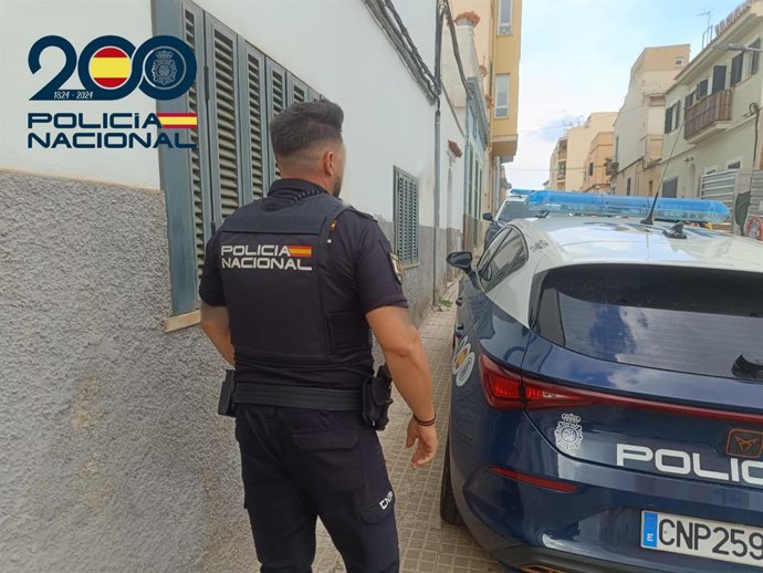 Un agente de la Policía Nacional junto a un vehículo policial