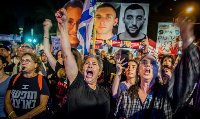 30 de setembro de 2025, Tel Aviv, Israel: Manifestantes israelenses gesticulam enquanto cantam e seguram um cartaz mostrando o refém israelense Matan Angriest durante uma manifestação. Pais de soldados de combate israelenses marcharam do quartel-general m