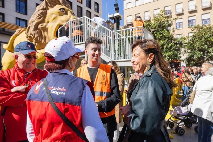 La alcaldesa de Zaragoza, Natalia Chueca, conversa con varios voluntarios de la ciudad junto al nuevo León Garganchón