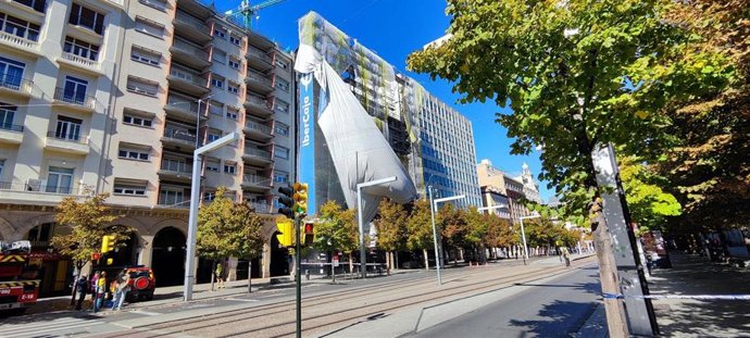 Lona desprendida en el edificio en obras del paseo de la Independencia que fue sede de la antigua CAI este domingo a las 15.20 horas y que ha llevado a los Bomberos de Zaragoza a intervenir para retirarla y a la Policía Local a cortar el tráfico.