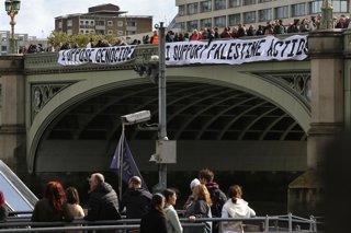 October 4, 2025, London, United Kingdom: Activists hold two banners over the side of Westminster Bridge saying â€�I oppose Genocide and I Support Palestine Actionâ€ during the protest, surrounded by police officers. Demonstrators risk arrest by hanging ba