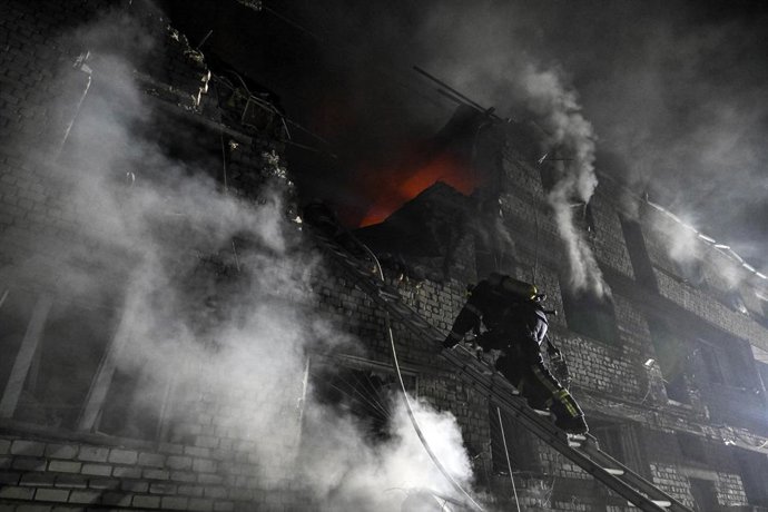 Archivo - Un bombero sube por la escalera en un bloque de apartamentos dañado por un ataque con drones rusos a gran escala en Zaporiyia, Ucrania