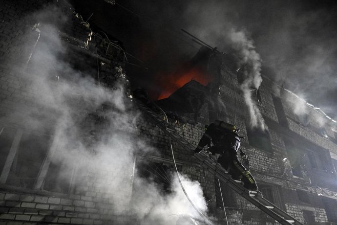 Archivo - Arquivo - 1º de maio de 2025, Zaporizhzhia, Ucrânia: Um bombeiro sobe a escada em um bloco de apartamentos danificado por um ataque de drones russos em grande escala em Zaporizhzhia, Ucrânia, em 1º de maio de 2025.
