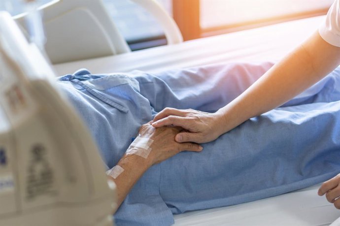 Archivo - Sanitario dando la mano a un paciente.