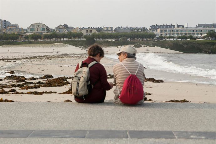 Archivo - Dos personas conversan durante la pleamar en el espigón de Foz, junto a la playa de A Rapadoira, a 19 de septiembre de 2024, en Lugo, Galicia (España). Galicia está hoy, 19 de septiembre, en aviso por las mareas vivas, que son las mareas que se 
