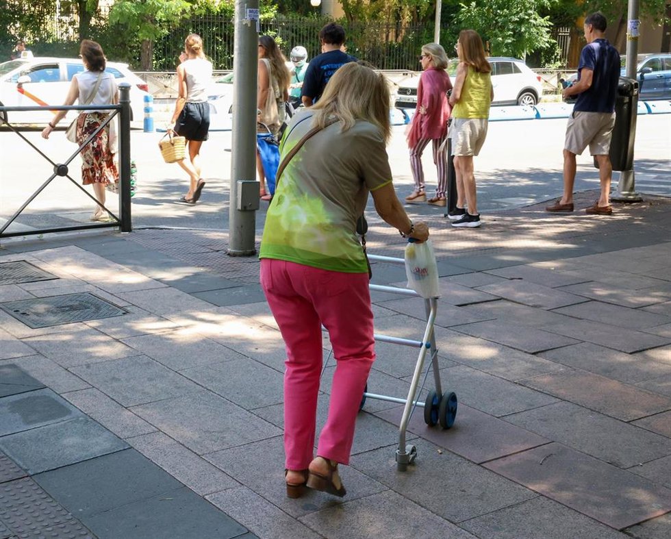 Archivo - Una mujer mayor caminando por la calle ayudada por un andador.