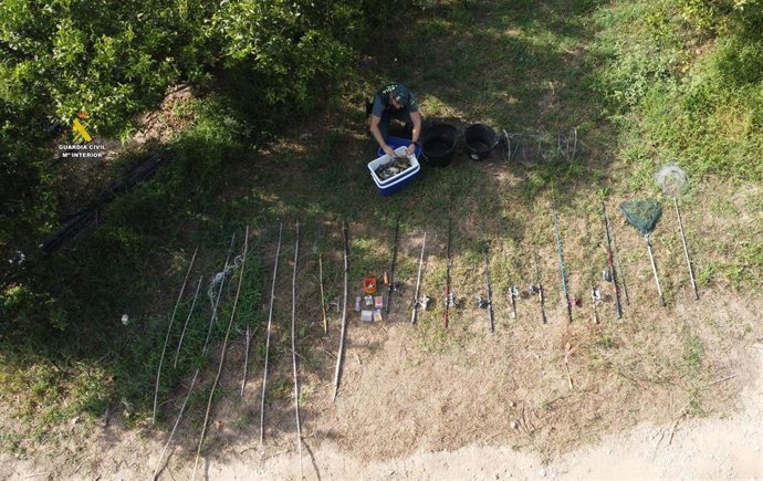 Agente del Seprona con las cañas y los cangrejos azules pescados de forma irregular