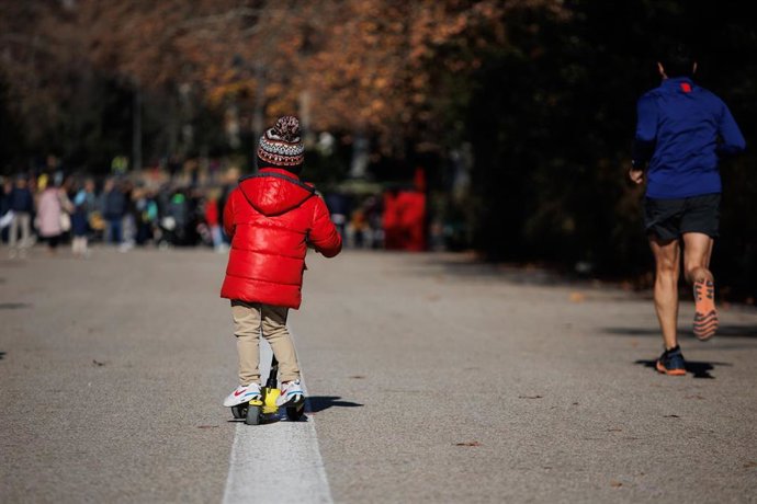 Archivo - Un niño sobre un patinete en un parque.