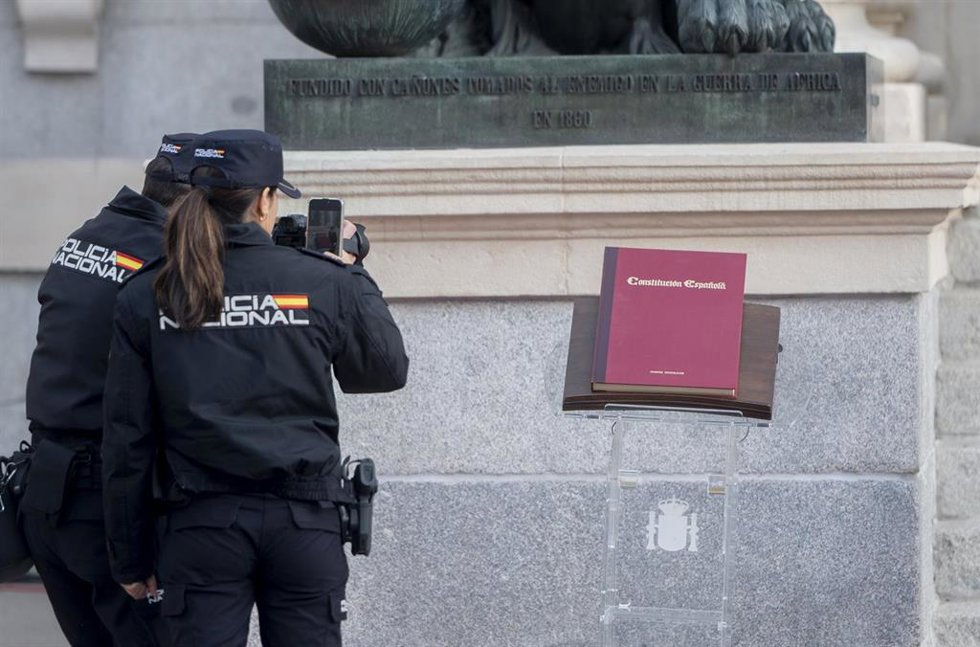 Archivo - Dos agentes de la Policía Nacional observan la Constitución