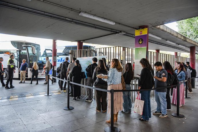Varias personas esperan autobuses alternativos al macrocorte en la línea R3 de Rodalies