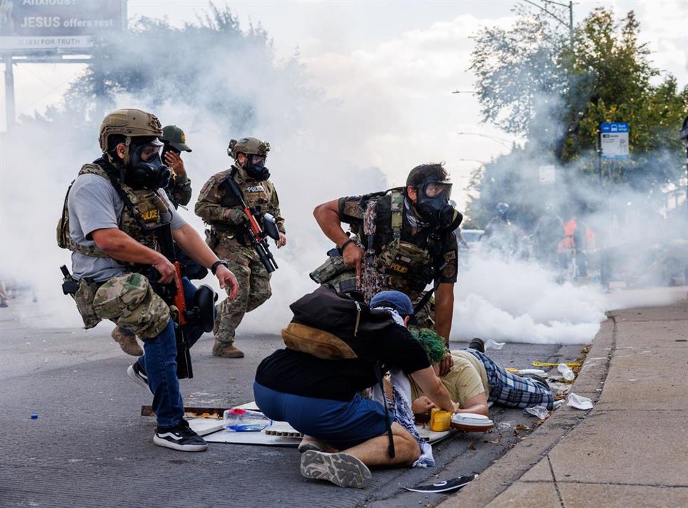 Agentes federales detienen a una persona mientras miembros de la comunidad y activistas protestan cerca de ellos, en Chicago, Illinois, Estados Unidos