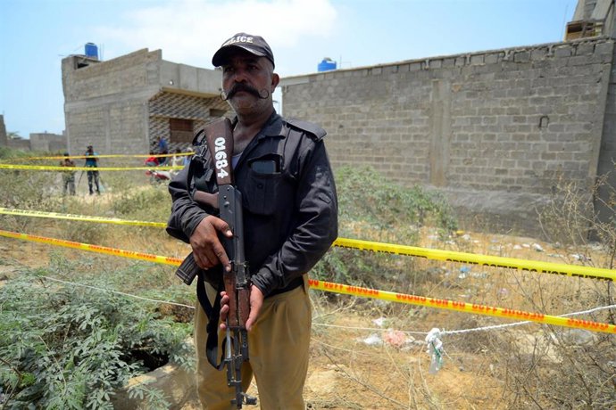 Archivo - Un policía de Pakistán frente a un lugar atacado por un dron de India en Karachi en el conflicto registrado en mayo de 2025 (archivo)
