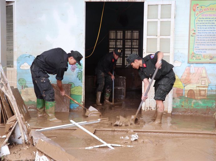 Imagen de archivo de varias personas limpiando una calle tras un tifón en Vietnam.