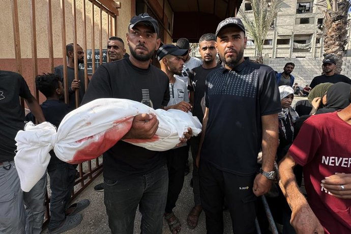 Archivo - Palestinos junto al cadáver de un niño muerto por los ataques del Ejército de Israel contra la Franja de Gaza, cerca del Hospital Naser de la ciudad de Jan Yunis (archivo)