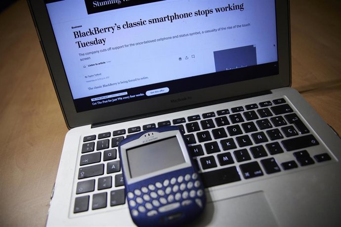Archivo - Un terminal BlackBerry con un ordenador portátil, en foto de recurso.