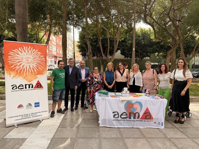 Representantes institucionales y miembros de la Asociación de Esclerosis Múltiple de Almería (AEMA) durante la instalación de la mesa informativa con motivo de la semana de sensibilización sobre la enfermedad.
