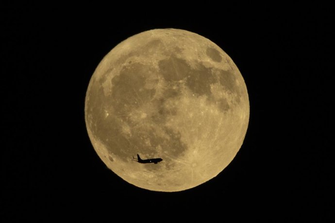 Archivo - 08 August 2025, US, Los Angeles: An airplane flies past a almost full moon rising over Los Angeles. Photo: Ringo Chiu/ZUMA Press Wire/dpa