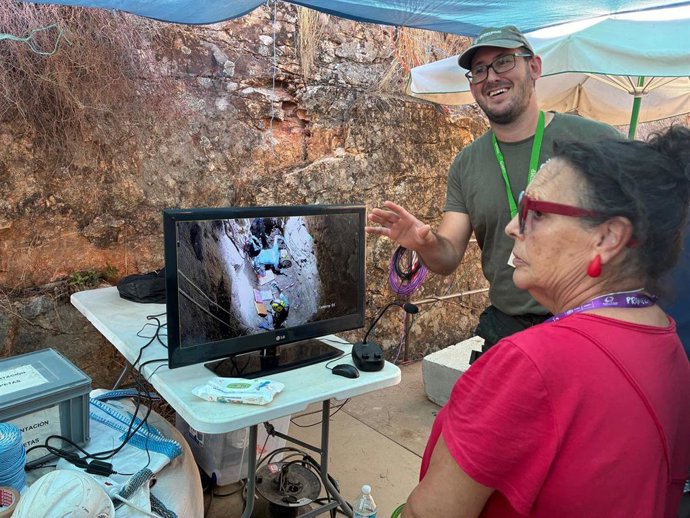 Una vecina observa los trabajos de exhumación en la mina La Paloma de Zarza la Mayor.