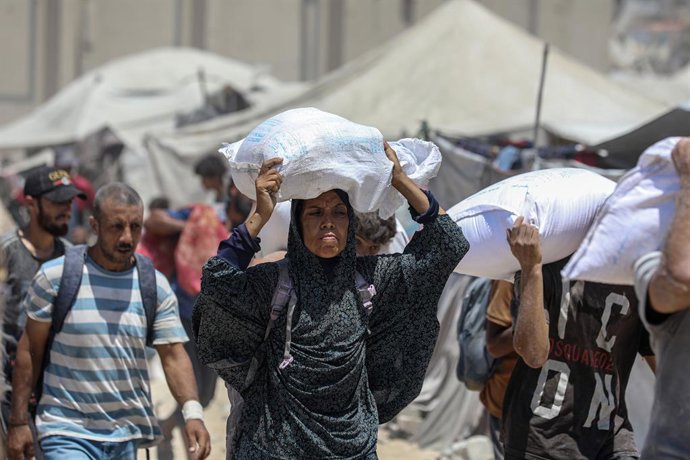 Archivo - August 1, 2025, Gaza City, Gaza Strip, Palestinian Territory: Palestinians carry bags of flour that they obtained from aid trucks which entered Gaza through the Zikim crossing point, in Jabalia in the northern Gaza Strip on August 1, 2025. The U