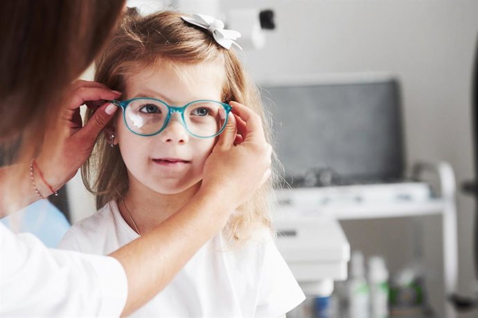 Archivo - Niña probándose unas gafas.