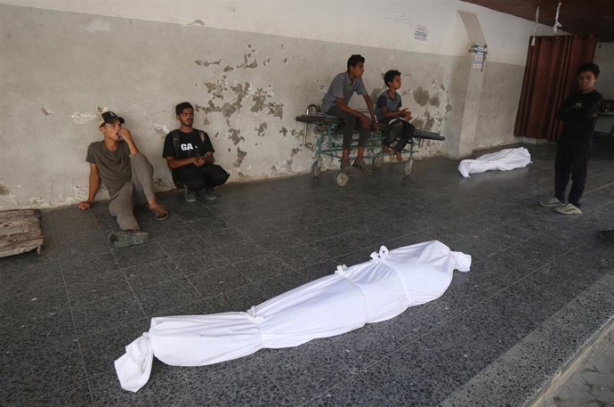 Archivo - Palestinos en el Hospital Al Ahli de la ciudad de Gaza junto a los cadáveres de varios muertos por los ataques del Ejército de Israel contra la Franja de Gaza (archivo)