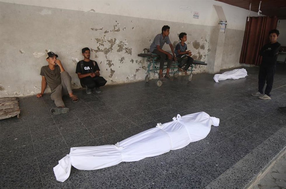 Archivo - Palestinos en el Hospital Al Ahli de la ciudad de Gaza junto a los cadáveres de varios muertos por los ataques del Ejército de Israel contra la Franja de Gaza (archivo)