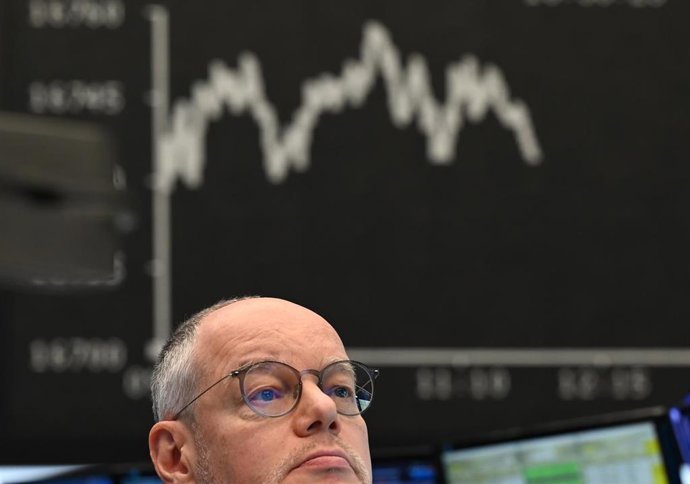 Archivo - 29 December 2023, Hesse, Frankfurt_Main: A stock exchange trader sits in front of the display board with the Dax curve in the trading hall of the Frankfurt Stock Exchange.