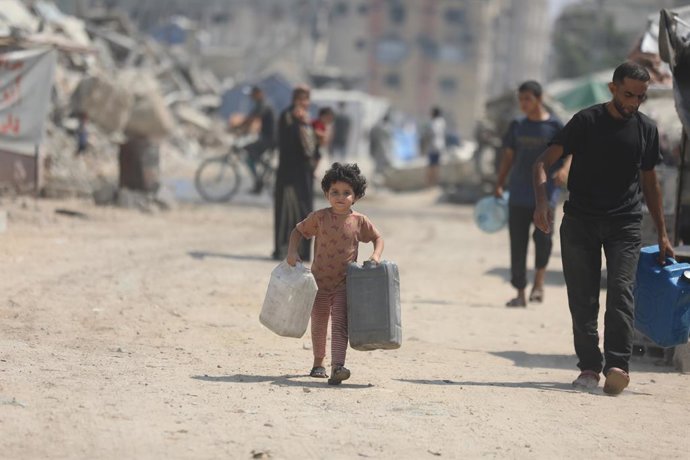 Archivo - 26 July 2025, Palestinian Territories, Gaza: Palestinian children try to meet their daily water needs by filling jerry cans from water tankers brought into the area in Gaza city, on July 26, 2025. In the Gaza Strip, which remains under Israeli a