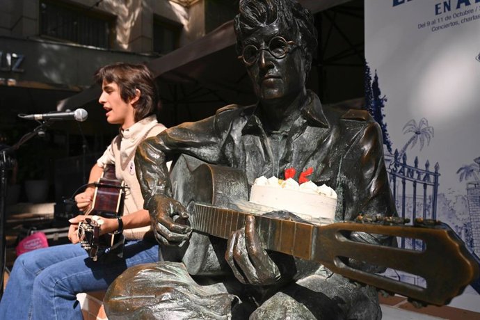 El artista John Juárez interpreta varias canciones junto a la estatua de John Lennon en la Plaza Flores de Almería.