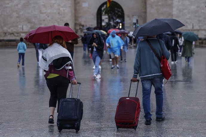 Varias personas con paraguas pasean, a 9 de octubre de 2025, en Valencia, Comunidad Valenciana (España). La Agencia Estatal de Meteorología (AEMET) ha activado la alerta naranja por precipitaciones en Valencia lo que ha obligado al Ayuntamiento a suspende