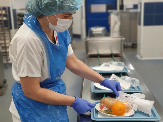Una trabajadora de las cocinas del HUN prepara un desayuno