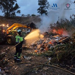 Un bombero del CPB actúa en un incendio en una acumulación de cañas, basura y enseres en el núcleo chabolista de Las Casillas de la Vía, en Torre del Mar, en Vélez-Mälaga.
